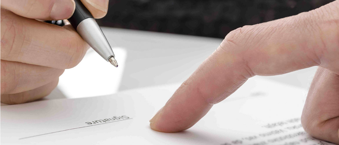 image of an attorney showing a client where to sign a document